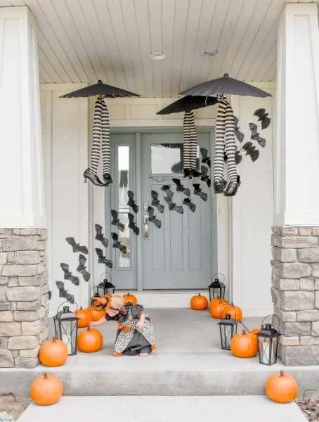 Halloween porch decorations with witch legs, bats and pumpkins