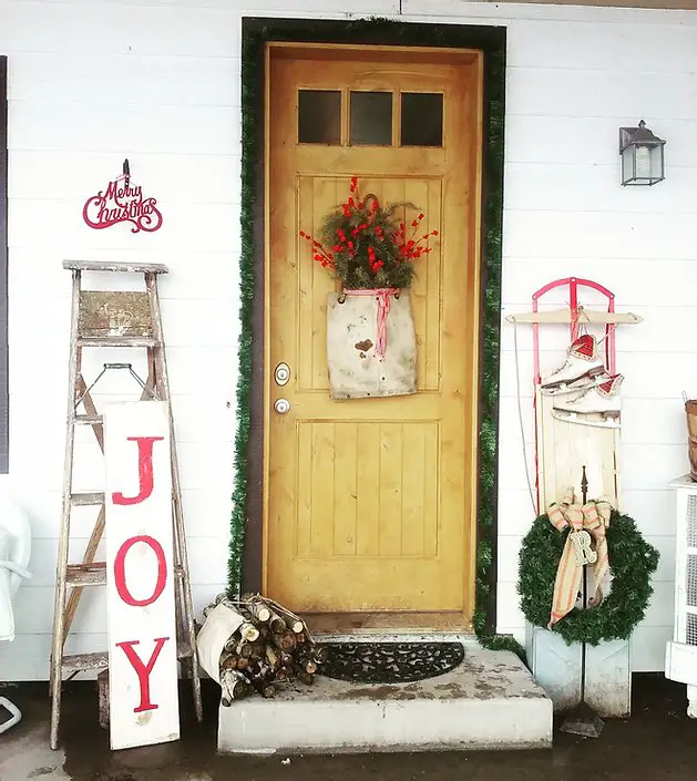 This vintage porch with pops of red is one of the Christmas porch ideas in this post. 