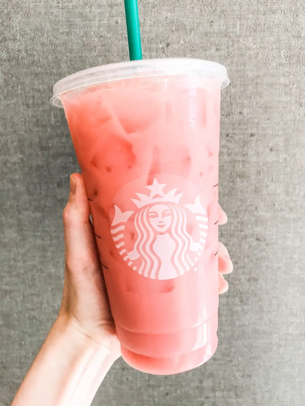 venti starbucks iced guava passionfruit drink with a grey textured background