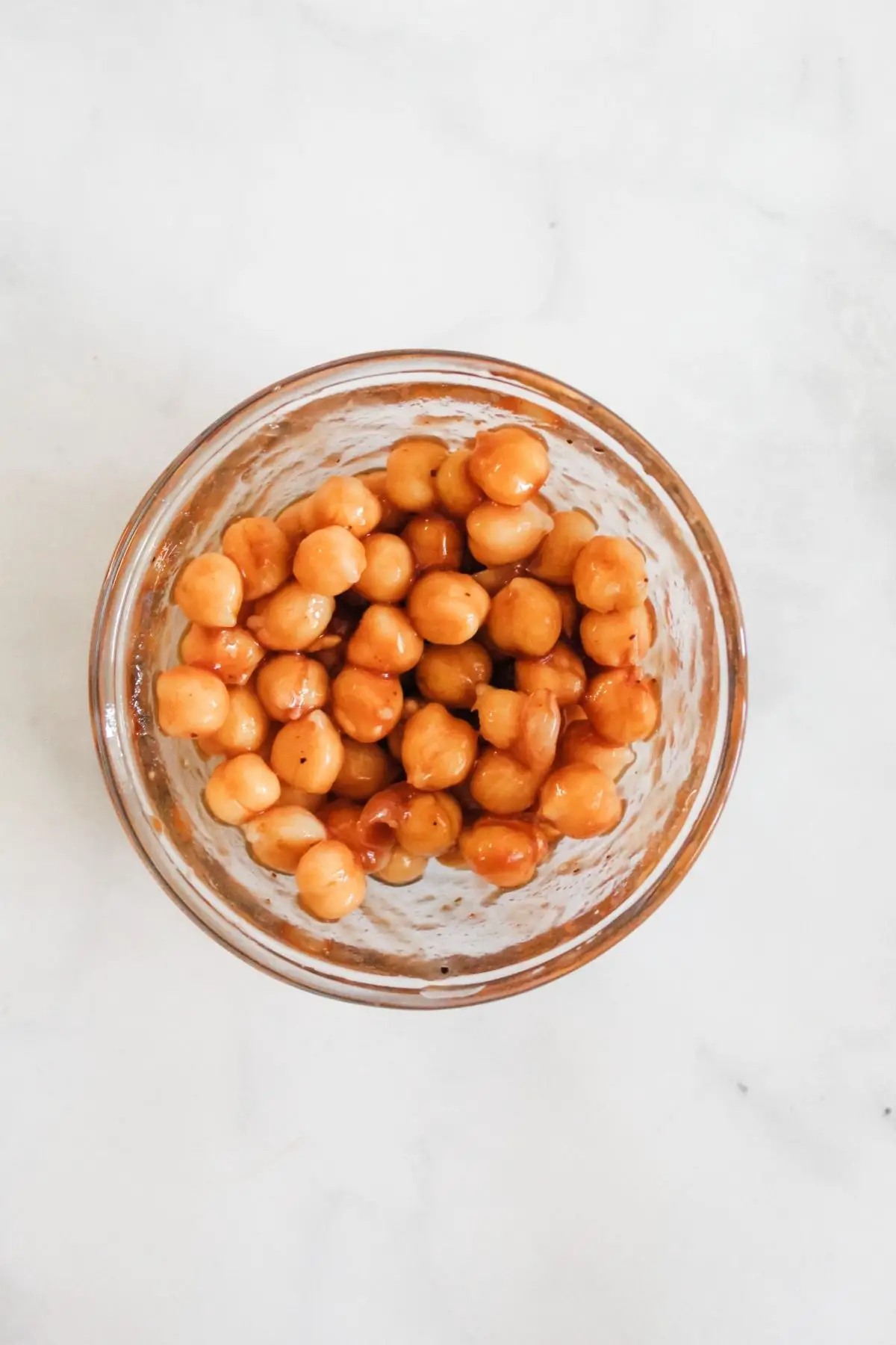 chickpeas tossed in vegan bbq sauce in a glass bowl