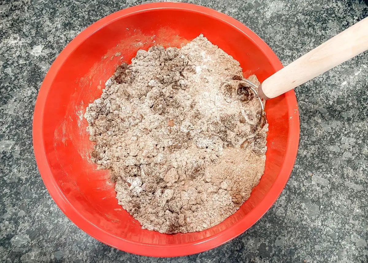 A mixing bowl and spoon with the ingredients to make edible dirt.