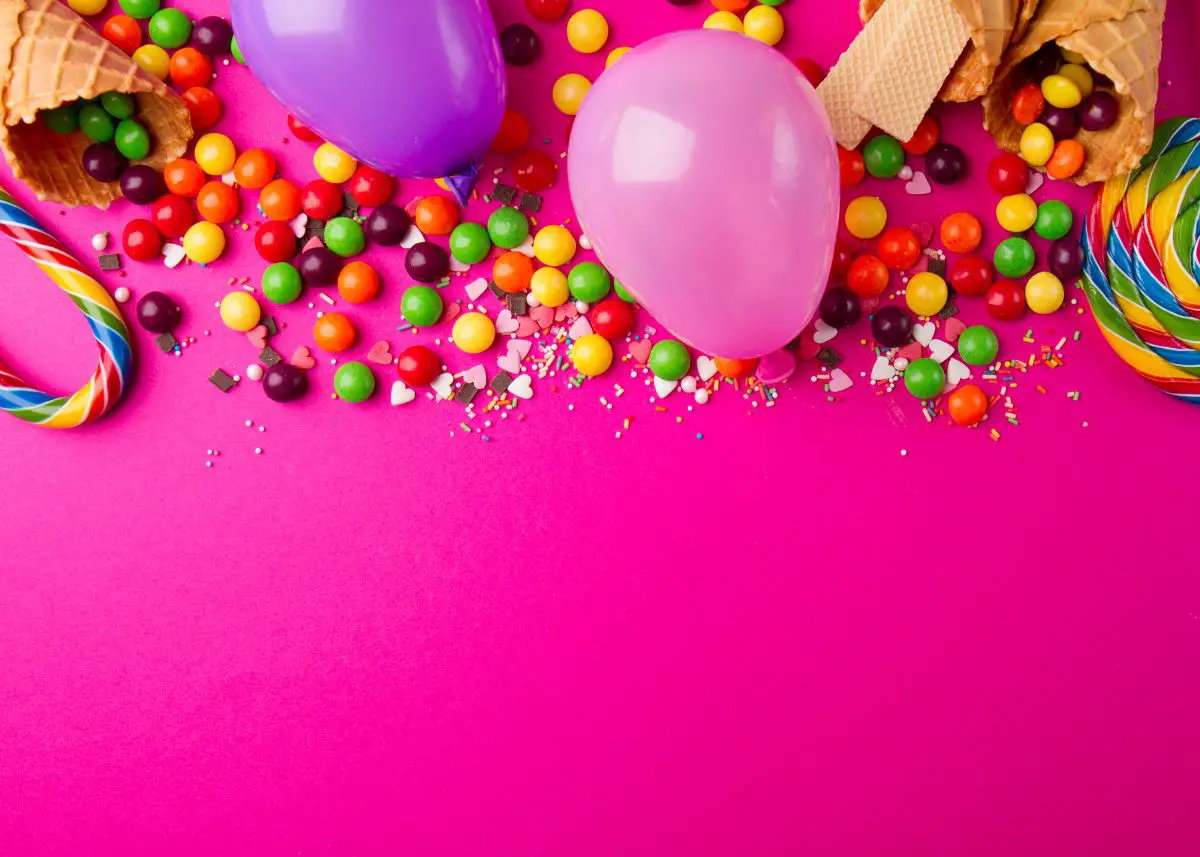 Pink and purple balloons with lollipops, skittles, waffle cones, and candy canes are on a hot pink background.