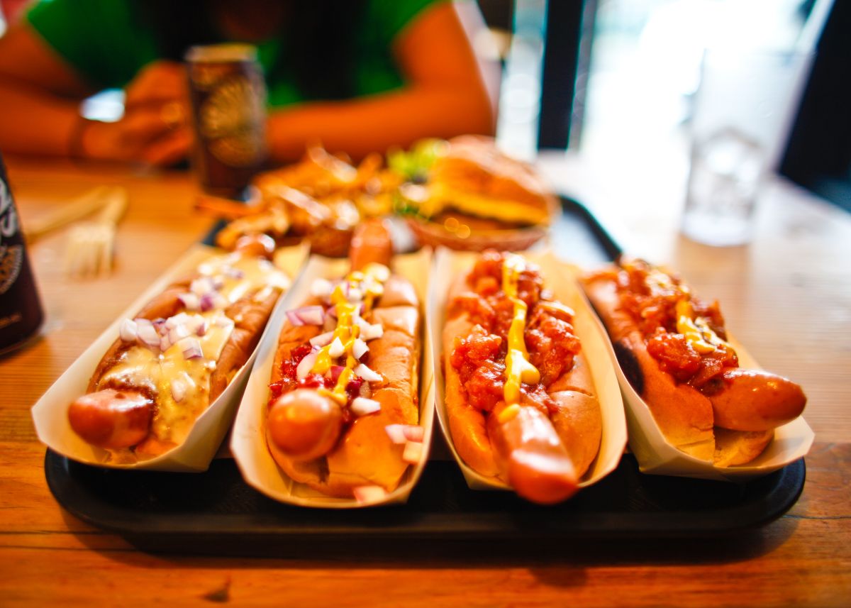 A closeup of four chili dogs.