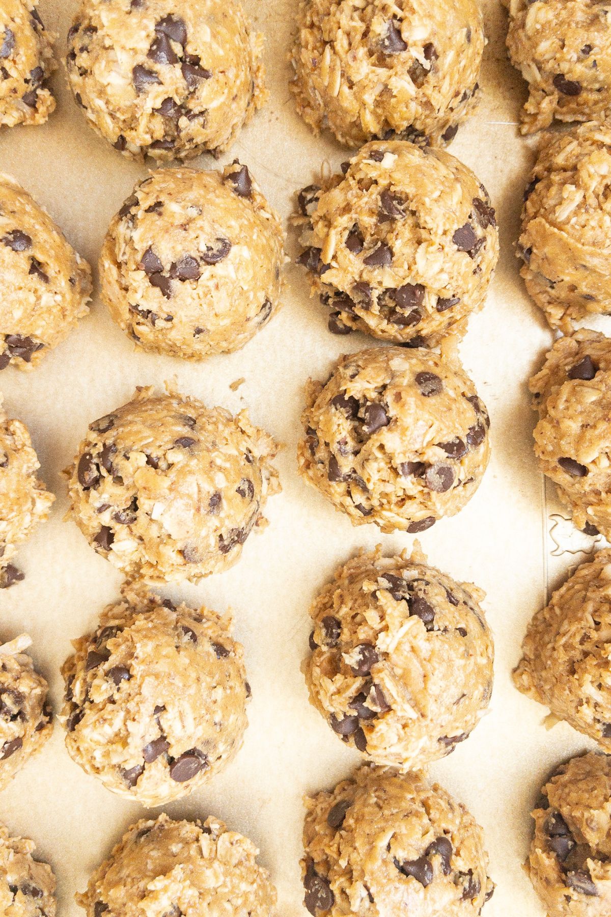 A closeup of 20 protein balls on a cookie sheet.