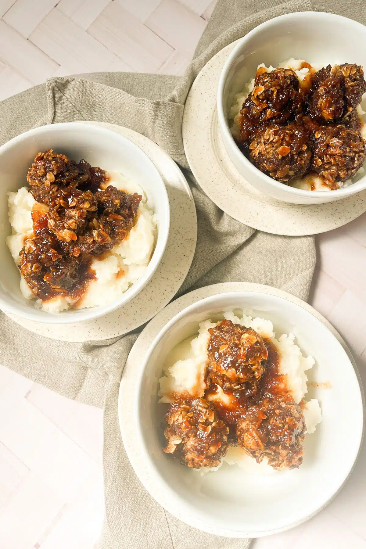 Three bowls of meatballs and mashed potatoes.