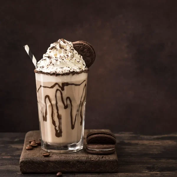 View of a cookies and creme frappuccino with Oreos and coffee beans around it