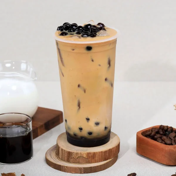 A Coffee Boba tea with coffee, cream, and coffee beans around it