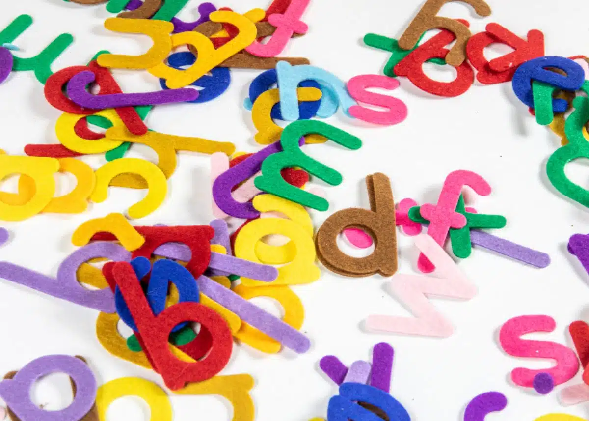 A bunch of colorful felt letters are in a pile.