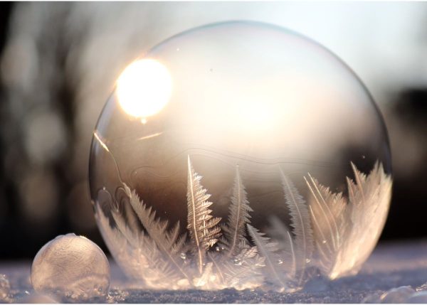 This is a closeup of a raindrop.  It's starting to freeze.  It's on the frozen ground.  The sun is starting to come up.  
