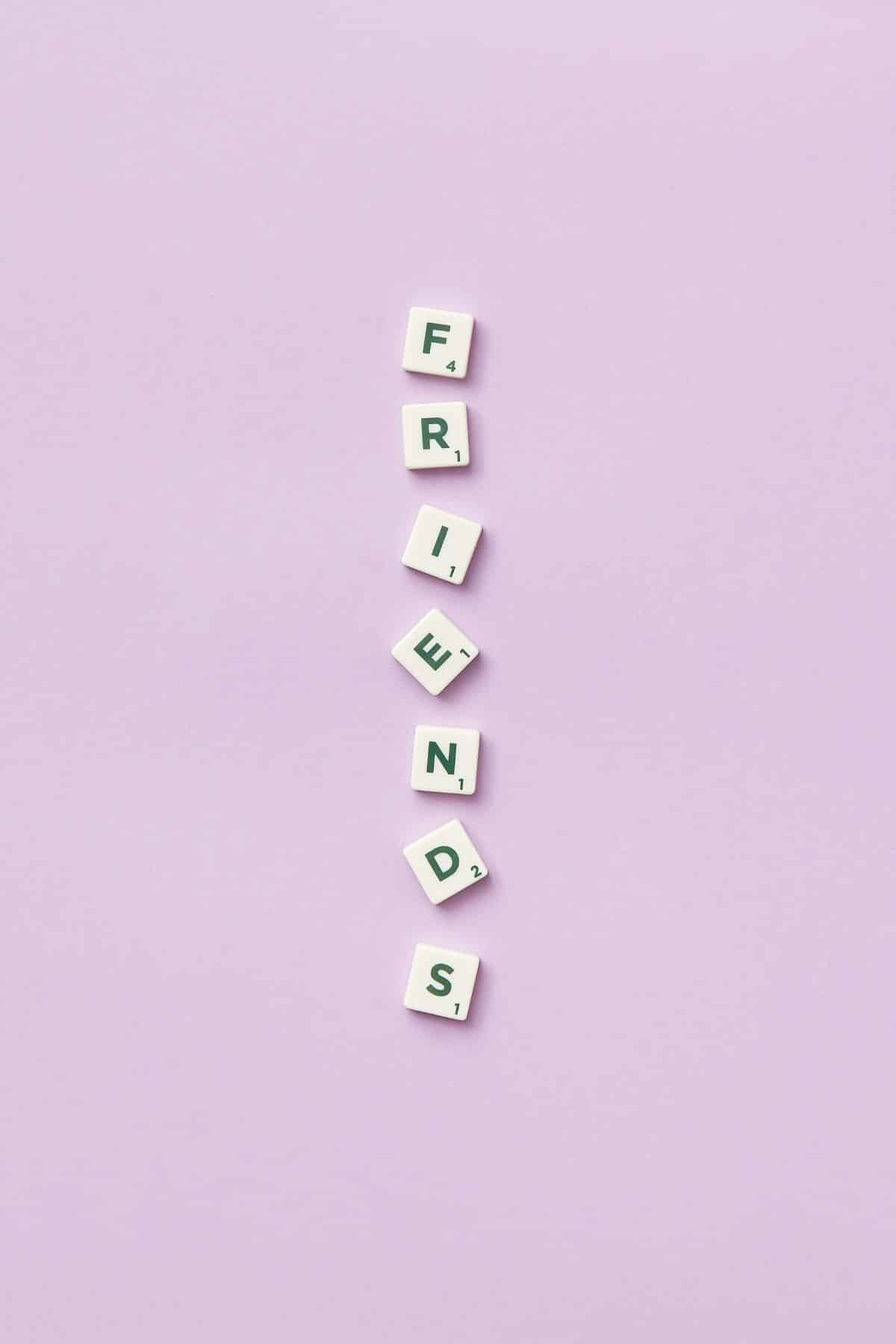 This is a picture of Scrabble tiles vertically spelling the word "Friends".  There is a purple background.