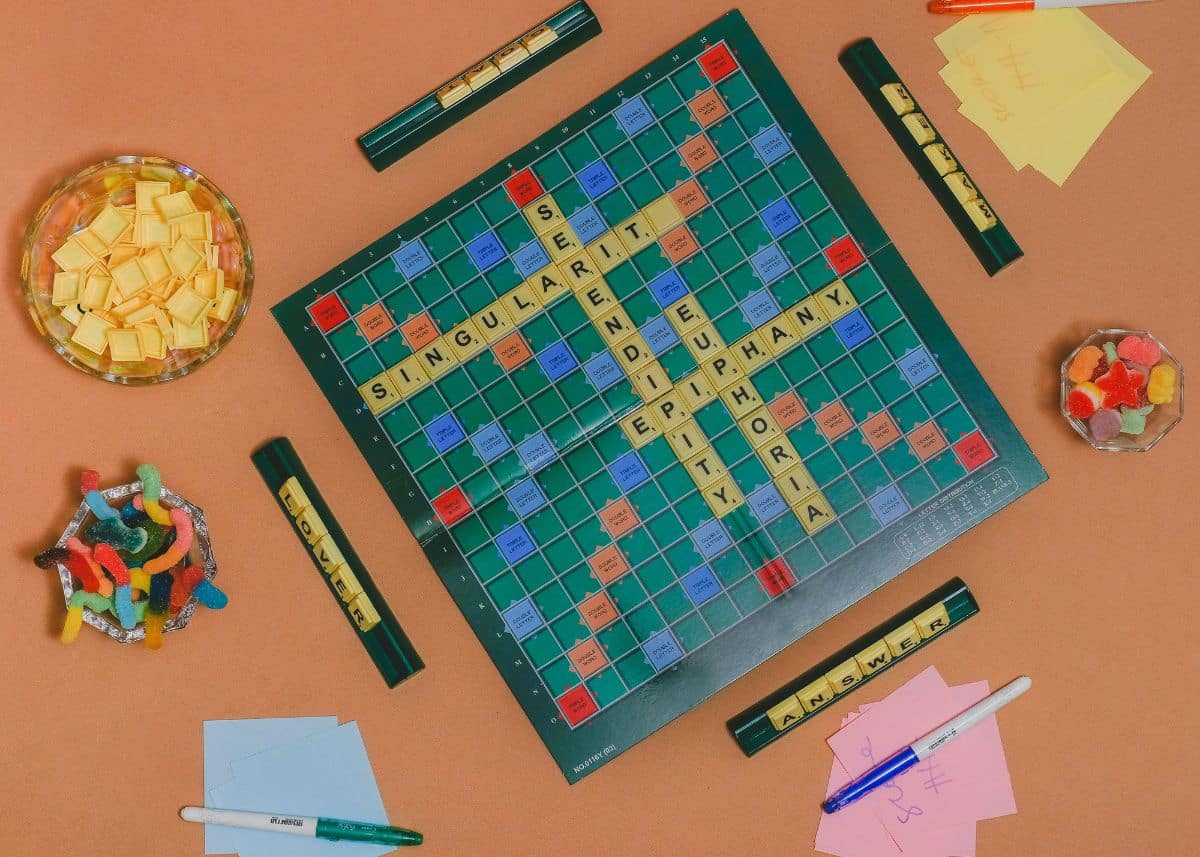 This is a bird's eye view of Scrabble.  There are four trays with letters in them.  There are also three bowls with treats.