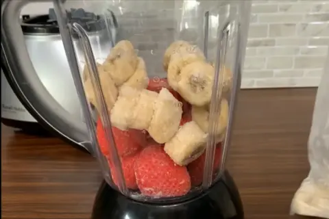 Add frozen strawberries and banana in a blender