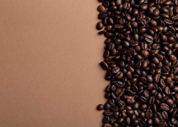 A closeup of coffee beans with a brown background.