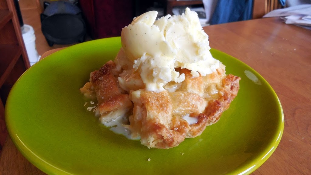 piece of classic peach pie with vanilla ice cream